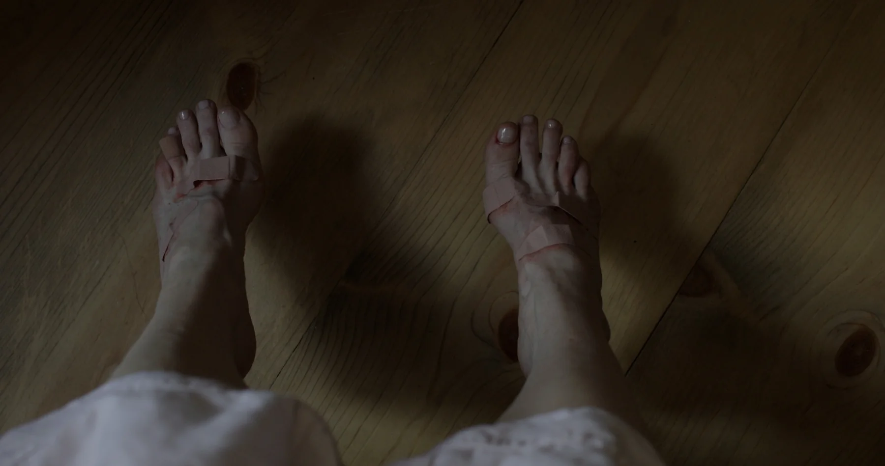 Bandaged feet on a wooden floor