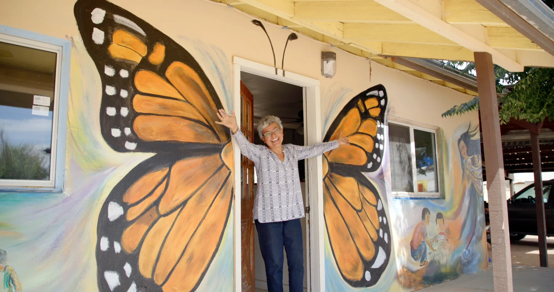 A woman framed by painted butterfly wings