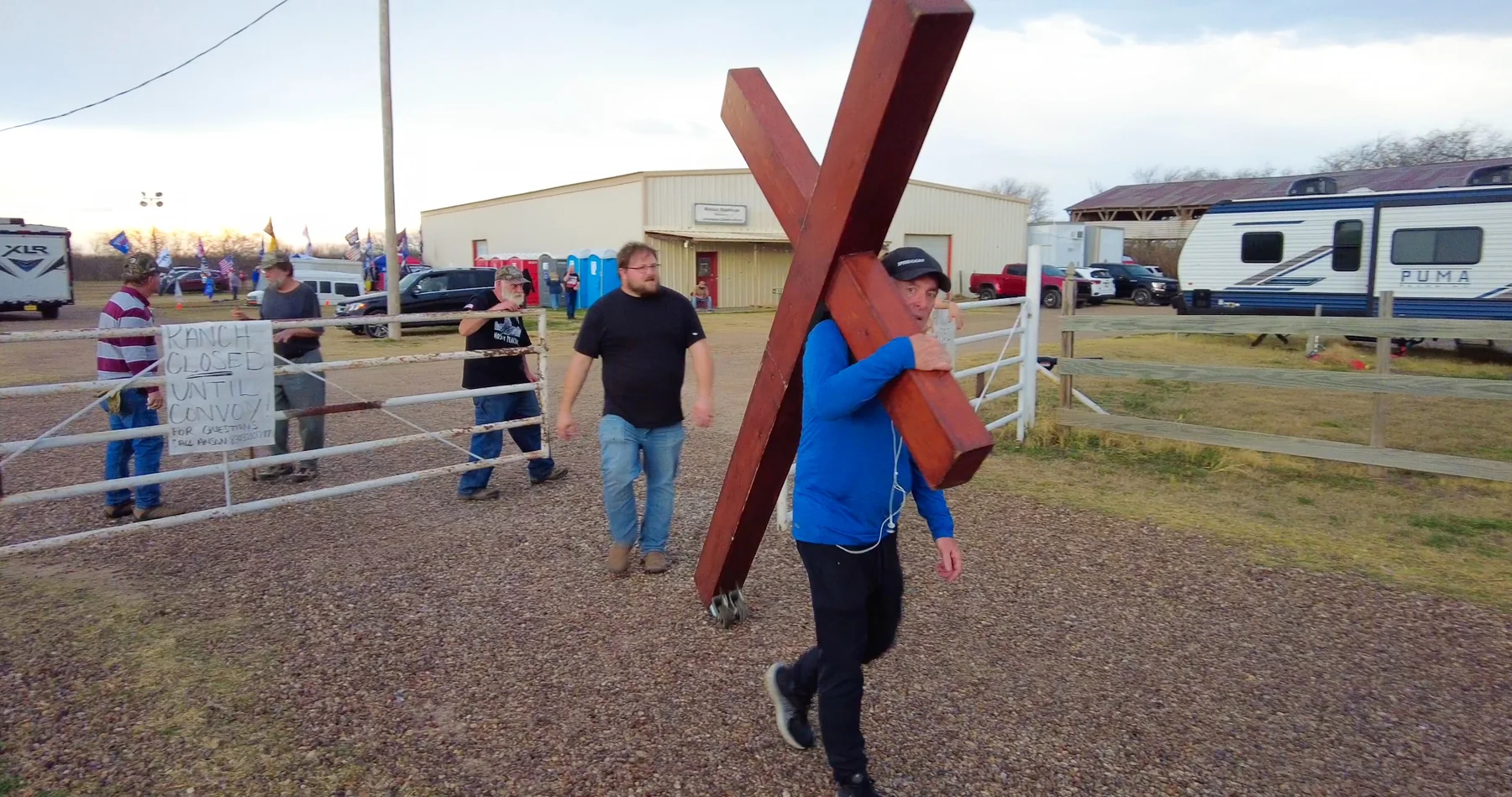 A man carrying a large wooden cross